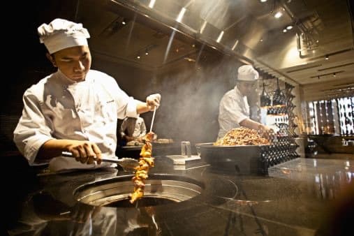 Un cuisinier au travail devant le tandoor